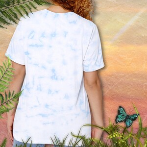 Blown Away Scottie - Blue and White Tie Dye Tee. Illustration of orange-red Scottie Head with wind blowing through the beard. Image of woman's back.