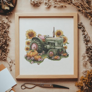 Peut inclure: Broderie au point de croix d'un tracteur vert avec des roues et un siège roses, entouré de tournesols et de citrouilles. L'œuvre est encadrée dans un cadre en bois clair, évoquant un thème rustique et automnal. Idéal pour la décoration intérieure.