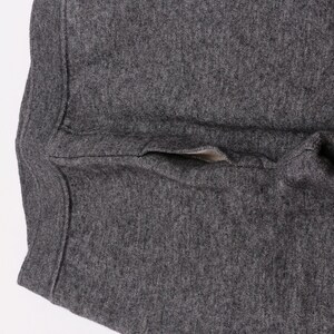 Puede incluir: Un pantal&oacute;n de ch&aacute;ndal gris oscuro con un solo bolsillo en la parte posterior.