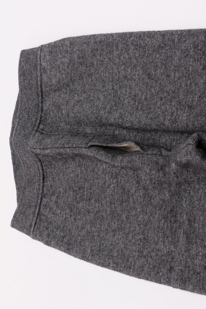 Puede incluir: Un pantal&oacute;n de ch&aacute;ndal gris oscuro con un solo bolsillo en la parte posterior.