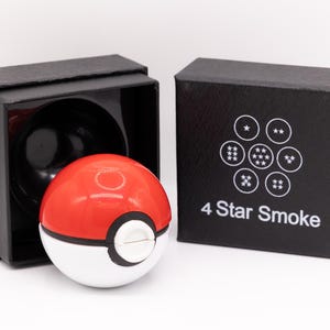 May include: A red and white sphere with a white button, resembling a Poké Ball, next to a black box. The box is open, revealing a black interior. A second black box displays the text "4 Star Smoke" and a white graphic.