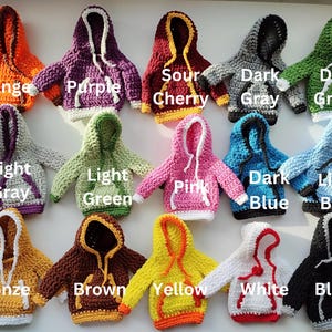 May include: Crocheted hooded sweaters in various colors, including orange, purple, sour cherry, dark gray, dark green, light gray, light green, pink, dark blue, light blue, bronze, brown, yellow, white, and black.