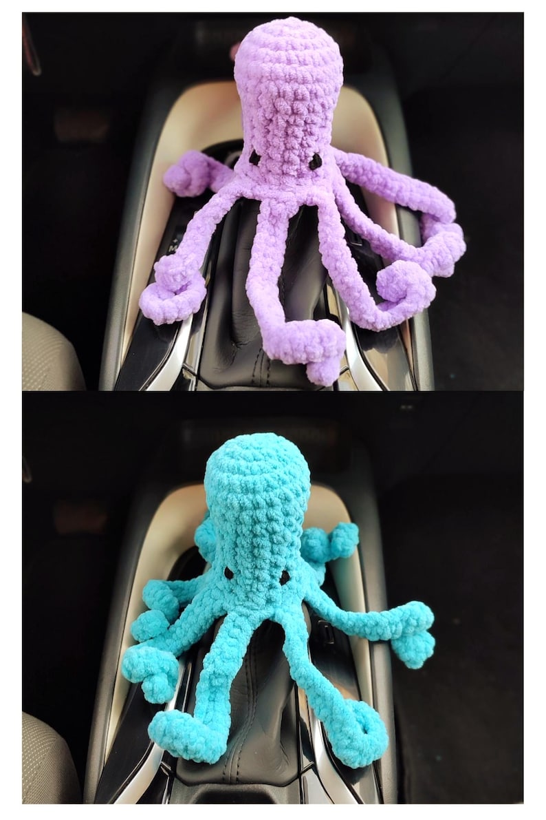 May include: Two crocheted octopus toys, one lavender and one turquoise, are displayed. The plush octopuses have multiple tentacles and small black eyes. The toys are sitting on a car's gear shift console.
