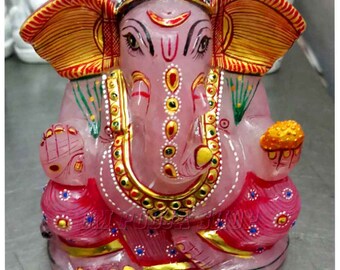 May include: Pink Ganesha statue with gold accents and painted details. The statue is made of rose quartz and features a traditional design.