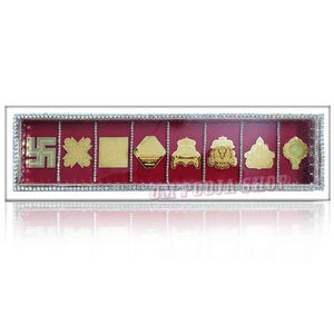 Puede incluir: Una vitrina rectangular con interior de terciopelo rojo, que muestra ocho símbolos religiosos dorados. La caja está enmarcada con un borde plateado y adornada con pequeños pedrería brillantes. Los símbolos están dispuestos en fila.
