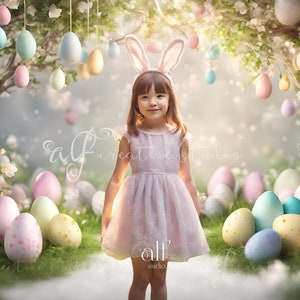 Pode incluir: Uma menina pequena com orelhas de coelho fica em frente a um cenário com uma árvore e ovos de Páscoa pastel pendurados nos galhos. A menina está usando um vestido rosa e tem um sorriso doce.