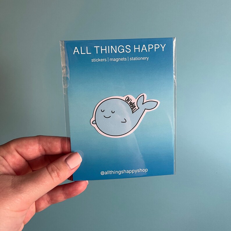 May include: A blue whale sticker with the text "Oh Whale" on it. The sticker is on a blue background with the text "All Things Happy" and "stickers | magnets | stationery" above it. The text "@allthingshappyshop" is below the sticker.
