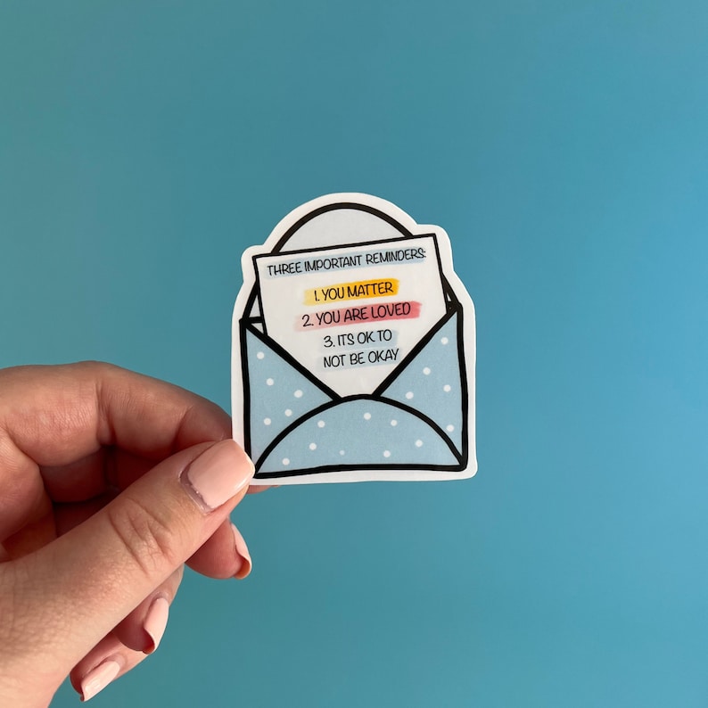 May include: A blue envelope sticker with white polka dots and a message inside that reads "THREE IMPORTANT REMINDERS: 1. YOU MATTER 2. YOU ARE LOVED 3. ITS OK TO NOT BE OKAY"