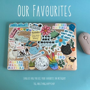 May include: A laptop covered in colorful stickers with various phrases and images, including "Make Waves", "You Are Enough", "Choose Happiness", "Be Kind", and "Mental Health Matters". The laptop is on a blue surface with a white wireless mouse next to it.