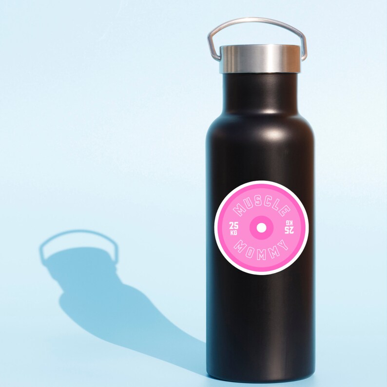 May include: Black water bottle with a pink and white sticker that says "Muscle Mommy" with a weight plate design.