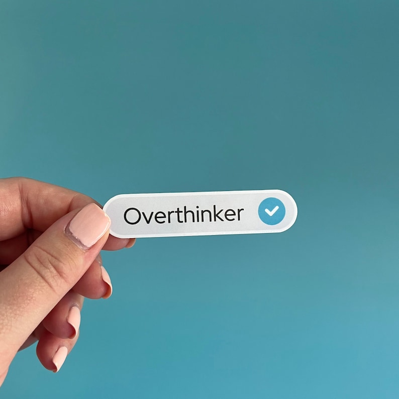 May include: White sticker with the text "Overthinker" and a blue checkmark.