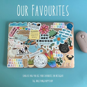 May include: A laptop covered in colorful stickers with various phrases and images, including "Make Waves", "You Are Enough", "Choose Happiness", "Be Kind", and "Mental Health Matters". The laptop is on a blue surface with a white wireless mouse next to it.