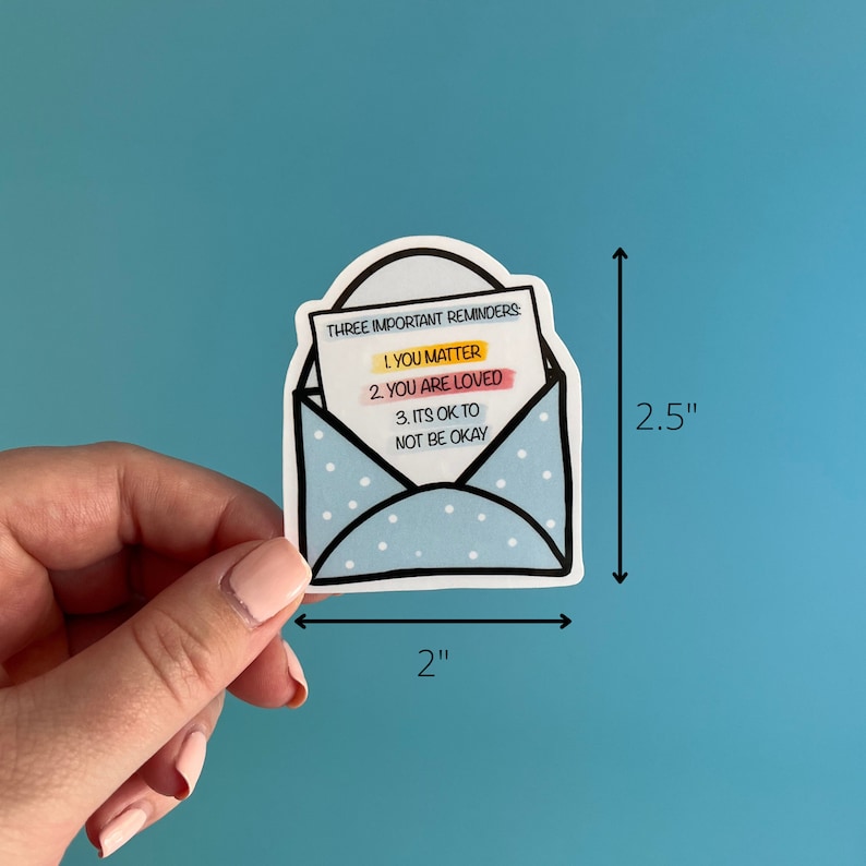 May include: A blue envelope sticker with white polka dots and a white note inside that reads "THREE IMPORTANT REMINDERS: 1. YOU MATTER 2. YOU ARE LOVED 3. ITS OK TO NOT BE OKAY". The sticker is 2 inches wide and 2.5 inches tall.