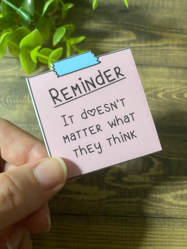 May include: Pink reminder note with a blue tape at the top. The note says "REMINDER IT doesn't matter what they think".