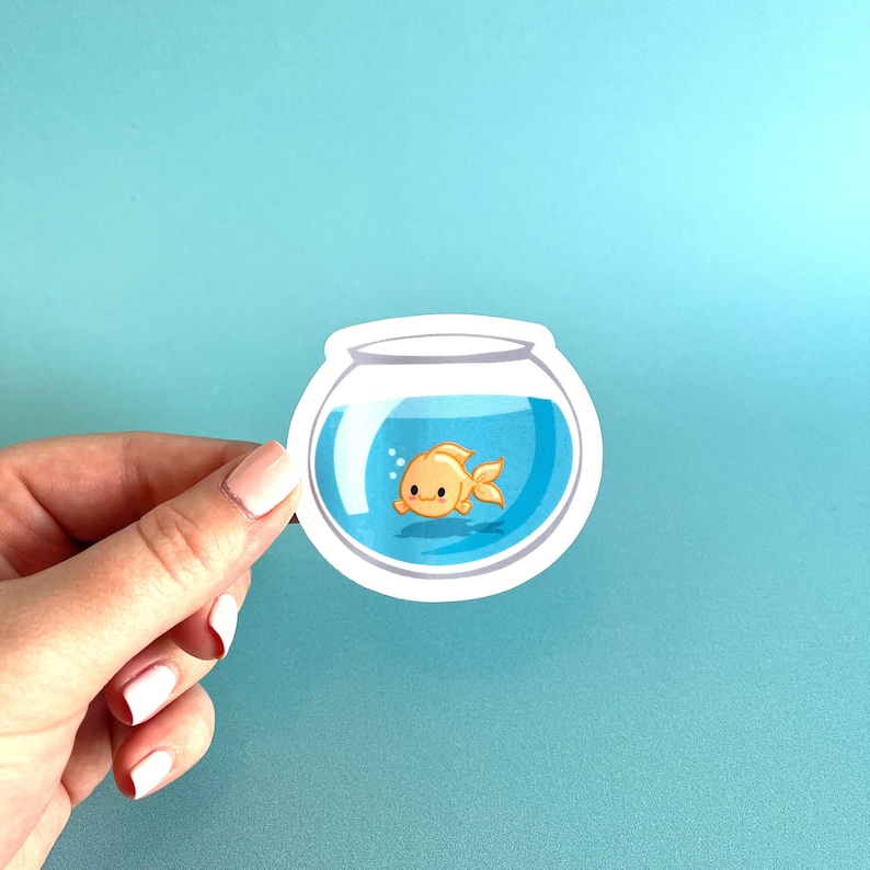 May include: A sticker of a goldfish swimming in a blue bowl. The sticker is white with a black outline.