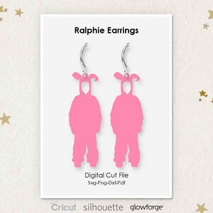 May include: A pair of pink bunny rabbit earrings with a digital cut file for crafting projects. The earrings are designed to look like the character Ralphie from the movie A Christmas Story. The text on the image reads "Ralphie Earrings, Digital Cut File, Svg-Png-Dxf-Pdf, Cricut silhouette glowforge".