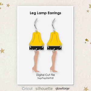 May include: A pair of earrings featuring a yellow lampshade with legs. The earrings are silver and have a hook closure. The image includes the text "Leg Lamp Earrings", "Digital Cut File", "Svg-Png-Dxf-Pdf", "Cricut", "silhouette", and "glowforge".