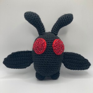 May include: Black crocheted moth plush toy with red beaded eyes.