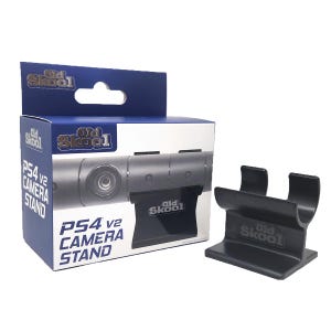 May include: A black plastic stand for a PS4 v2 camera. The stand has the words "Old Skool" printed on it. The stand is shown next to a box with the words "PS4 v2 Camera Stand" printed on it.