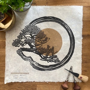 May include: A black and brown woodblock print of a bonsai tree with a circle around it on a white background. The print is signed "PeppermintCarrot" and dated "6/60 - 2022".