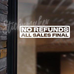 May include: White rectangular sticker with the text "NO REFUNDS ALL SALES FINAL" in a bold, sans-serif font. The sticker is displayed on a glass surface, with a stone wall visible on the left side. The sticker is likely for a retail business.