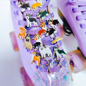 May include: Purple roller skates with a variety of dog charm shoe laces. The charms are in different breeds and colors.