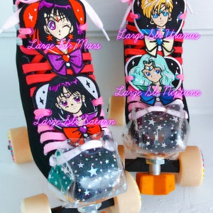 May include: Pair of black roller skates with pink laces and orange wheels. The skates feature anime character designs with the text "Large Slr Mars", "Large Slr Uranus", "Large Slr Neptune", and "Large Slr Saturn". The toe stops are clear with a star pattern.