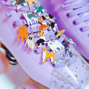 May include: Purple roller skates with a variety of colorful dog charms attached to the laces. The charms are made of metal and feature different dog breeds.