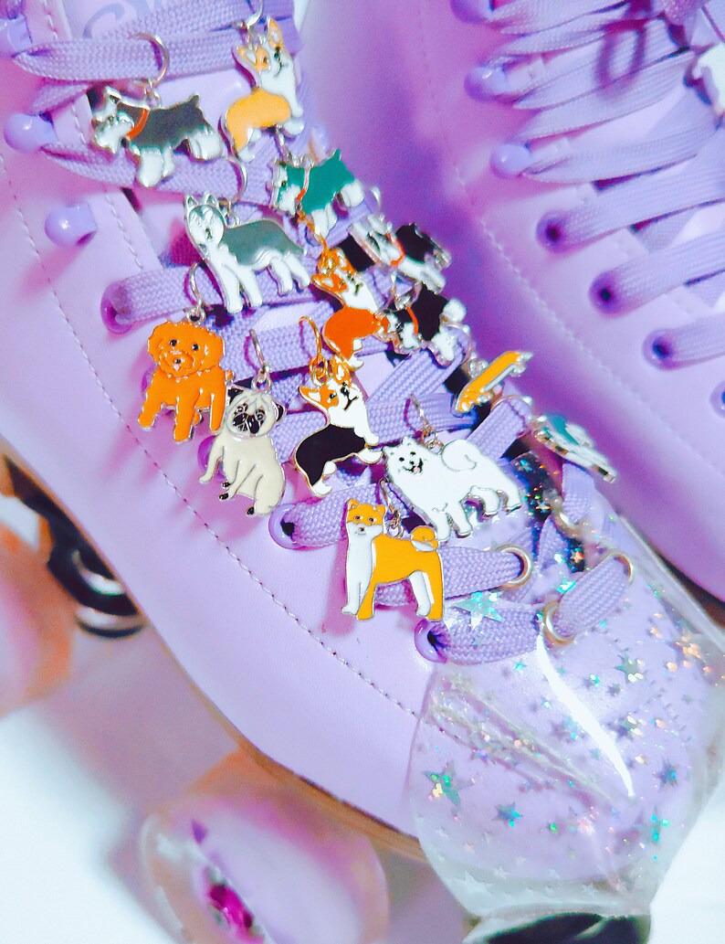 May include: Purple roller skates with a variety of colorful dog charms attached to the laces. The charms are made of metal and feature different dog breeds.