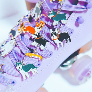 May include: Purple roller skate with colorful dog charms attached to the laces. The charms are of different breeds, including a corgi, a husky, a dachshund, and a terrier.
