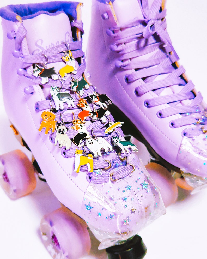 May include: Purple roller skates with a clear, star-shaped toe stop. The laces are decorated with a variety of small dog charms.