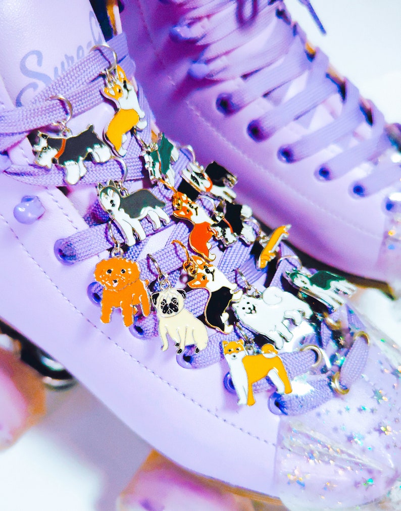 May include: Purple roller skates with a variety of colorful dog charms attached to the laces. The charms are made of metal and feature different dog breeds.
