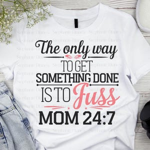 May include: White t-shirt with black text that reads "The only way to get something done is to fuss MOM 24:7". The word "fuss" is in pink.
