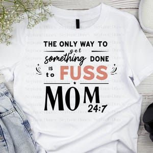 May include: White t-shirt with black text that reads "The only way to get something done is to fuss Mom 24:7". The word "fuss" is in pink.