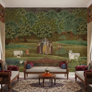 May include: A large wall mural depicting a lush green landscape with fruit trees, figures in traditional attire, and white cows. The scene is set behind a wooden sofa and two armchairs with red cushions, arranged on a patterned area rug.