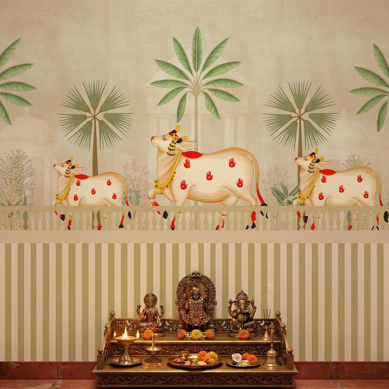 May include: A decorative wall mural featuring three cream-colored cows adorned with red handprints and gold accents. Palm trees and a white fence are also depicted. Below, a golden altar displays religious statues and offerings.