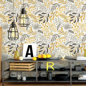 Puede incluir: Una estanter&iacute;a de metal negro con tres estantes, con un fondo blanco con un patr&oacute;n floral amarillo y gris. La estanter&iacute;a est&aacute; decorada con una caja de madera, una peque&ntilde;a planta en maceta y algunos art&iacute;culos decorativos.