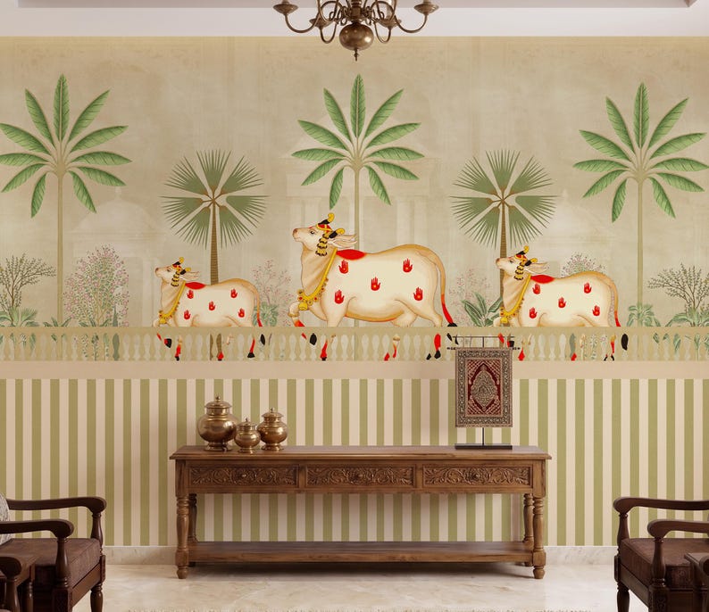 May include: A decorative wall mural featuring a cream-colored background with green palm trees and three cream-colored cows with red and gold accents. The lower portion of the wall has vertical green and white stripes. A wooden console table and decorative items are in front.