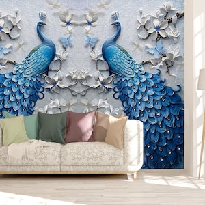Könnte beinhalten: Eine weiße Wandmalerei mit 3D-Effekt, die zwei blaue Pfauen mit ausgebreiteten Schwänzen zeigt. Die Pfauen sind von weißen Blumen und Schmetterlingen umgeben.