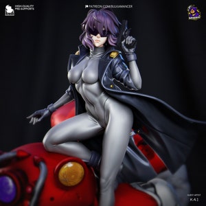 May include: A 3D printed model of a female character wearing a black coat and a silver jumpsuit. She is holding a gun in her right hand and has purple hair. The character is standing on a red and silver mechanical object.