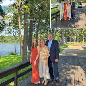 May include: A group of three people standing on a wooden deck. One person wears a floor-length orange dress, another wears a patterned orange and yellow blouse with light-colored trousers, and the third wears a dark blue suit with a light blue shirt.