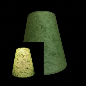 May include: Two green lampshades made of textured paper. The larger lampshade is a darker green and the smaller lampshade is a lighter green.