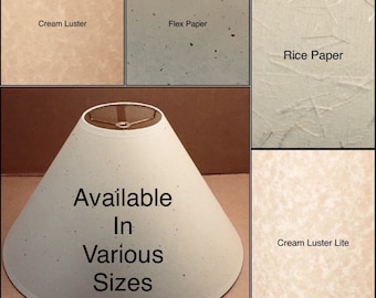 May include: A white lampshade with a conical shape and a gold metal frame. The lampshade is available in various sizes and is made of cream luster, flex paper, rice paper, and cream luster lite.