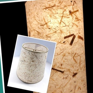 May include: A white lampshade with a textured, paper-like surface. The shade has a brown, metallic trim around the top edge.