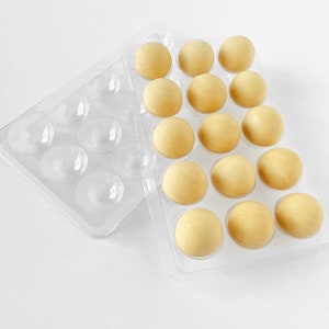 May include: Two clear plastic containers with 18 round, pale yellow, dough balls. The containers are designed to hold the balls in a grid pattern.