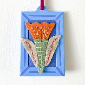Miniatyrblommig folkkonst, ornament, handbroderad, handmålad med rektangulär metallram med sammetsögla