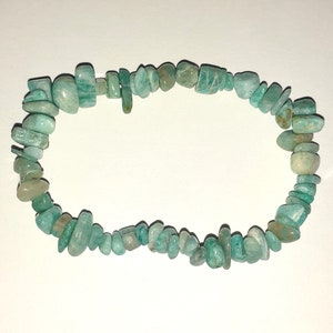 May include: A green gemstone bracelet made of small, irregular shaped beads. The bracelet is made of natural stones and is a beautiful example of handmade jewelry.