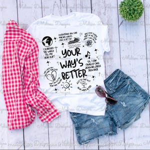 Puede incluir: Camiseta blanca con el texto "Your Way's Better" y varias ilustraciones negras. La camiseta se combina con pantalones cortos de mezclilla, gafas de sol y una camisa a cuadros roja y blanca. Una pequeña planta verde también está en la imagen.