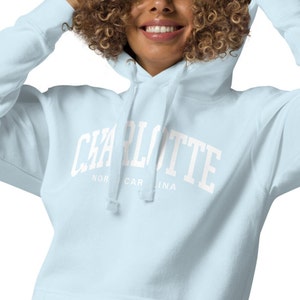May include: Light blue hooded sweatshirt with white text that reads "CHARLOTTE NORTH CAROLINA".