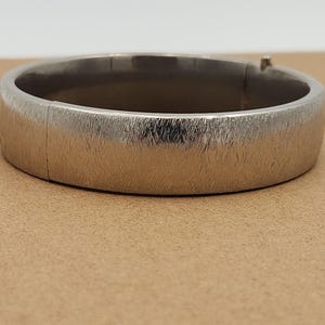 May include: A set of three ceramic vases in varying heights and shapes. The vases are glazed in a matte white finish, offering a minimalist aesthetic. The tallest vase is approximately 10 inches high.